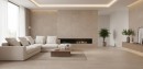 Elegancki salon z podłogą i ścianą kominkową wyłożoną beżowymi płytkami Marazzi Room Taupe Strutturato 30x60 cm MP6W o teksturze naturalnego kamienia, ciepła kolorystyka gresu harmonizuje z jasną sofą i drewnianymi meblami