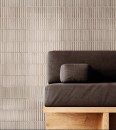 Stylowa strefa relaksu z płytkami Peronda Harmony Crisp Taupe 20x20. Ryflowana, beżowo-szara struktura ściany tworzy nowoczesne tło dla drewnianych mebli i miękkich tekstyliów. Elegancja w stylu Soft Minimal.