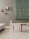 Mozaika szklana, dekoracyjna w zielonym odcieniu, Lantic Colonial Kronos Jade 21,3x35,1 100363570 położona na ścianie w pomieszczeniu z szarą ścianą, marmurową półką oraz waz wazonem