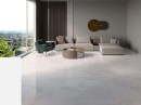 Przestronny salon z podłogą CIL Alpi Full-Lappato 60x120. Biały, polerowany gres imitujący marmur efektownie odbija światło, tworząc luksusowe tło dla szarej sofy i zielonego fotela. Nowoczesna klasyka w wysokim połysku.