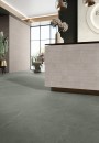 Wnętrze salonu fryzjerskiego z ladą z różowymi płytkami cegiełkami oraz szarymi płytkami podłogowymi imitującymi kamień Caesar Slab2 Jade