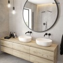 Łazienka z dużym okrągłym lustrem, betonowymi płytkami, drewnianą szafką wiszącą, czarnymi podstynkowymi bateriami oraz białymi nablatowymi umywalkami Oltens Hamnes 47,5x34 z powłoką SmartClean 40809000