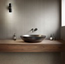 Nowoczesna łazienka z płytkami 3D Marazzi Room Wall Match Grigio 30x90 cm MP6C na ścianie nad drewnianym blatem z czarną umywalką nablatową
