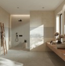 Jasna, nowoczesna łazienka wykończona białymi płytkami ściennymi Marazzi Room Wall Bianco 20x60 MQ7D, które imitują naturalny kamień. Wnętrze uzupełniają minimalistyczne akcenty, takie jak drewniana drabinka na ręczniki, długa szafka podumywalkowa