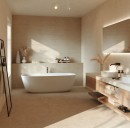 Przytulna, nowoczesna łazienka wykończona ściennymi płytkami Marazzi Room Wall Beige 20x60 MQ7E w ciepłym odcieniu beżu, wnętrze z wolnostojącą wanną i drewnianymi meblami emanuje spokojem, podkreślonym przez matową strukturę ceramiki imitującej kamień