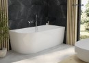 Oltens Delva komfortowa wanna wolnostojąca 170x80 cm narożna prawa w klasycznej bieli 11001000 wanna stoi w narożniku łazienki z ciemnymi płytkami na ścianie oraz jasną podłogą oraz dużym oknem