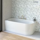 Oltens Hulda subtelna w formie wanna wolnostojąca narożna lewa o wymiarach 170 × 80 cm, wykończona w klasycznej, błyszczącej bieli 11005000 wanna znajduje się w jasnej łazience, z drewnianą podłogą oraz mozaiką na ścianie