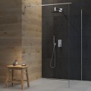 Oltens Zestaw Gota podtynkowa bateria z deszczownicą 30 cm Sondera (S) oraz zestawem prysznicowym Sog w chromowanym wykończeniu 36601100 zestaw zamontowany w łazience z czarnymi płytkami oraz drewnianym taboretem