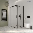 Oltens Breda kabina prysznicowa 100x80 cm prostokątna czarny mat/szkło przezroczyste 20221300 kabina zamontowana w jasnej łazience z jasnymi płytkami oraz czarnym grzejnikiem na ścianie