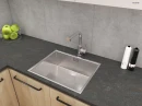 Oltens Myvat bateria kuchenna stojąca z wyciąganą wylewką chrom 35205100 - bateria zamontowana w kuchni z ciemnym blatem, szarymi płytkami na ścianie oraz szafkami drewnopodobnymi