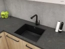 Oltens Myvat bateria kuchenna stojąca z wyciąganą wylewką czarny mat 35205300 - bateria zamontowana w kuchni z ciemnym blatem, szarymi płytkami na ścianie oraz drewnopodobnymi szafkami