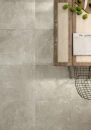 Wnętrze z drewnianym stołem i płytkami podłogowymi imitującymi beton Caesar Step In Taupe