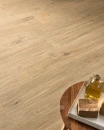 Wnętrze z beżową płytką podłogową drewnopodobna z wyraźnym rysunkiem słojów Caesar Step Arthis Vapor