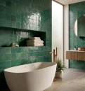 Stylowa łazienka z płytkami Marazzi Lume Green Lux 10x10. Błyszcząca, szmaragdowa ceramika na ścianach tworzy luksusowe tło dla wolnostojącej wanny i miedzianej armatury. Rzemieślnicza struktura płytek nadaje wnętrzu unikalny, nastrojowy klimat SPA.