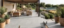 Nowoczesny taras wyłożony wielkoformatowymi, szarymi płytkami gresowymi Marazzi Slow Cold20 Cemento 60x120 o grubości 20 mm (MPZT). Płytki imitujące beton stanowią tło dla mebli ogrodowych, donic i basenu