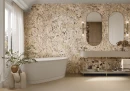 Gres Graniti Alaska White 60x120 o naturalnej strukturze granitu w eleganckiej łazience. Jasnoszara podłoga i ściany doskonale współgrają z białą wanną wolnostojącą, drewnianą konsolą z umywalką oraz okrągłym lustrem. Całość dopełniają czarne akcenty.