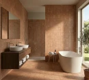 Nowoczesna łazienka ze ścianami i podłogą wyłożonymi beżowo-brązowymi, kwadratowymi płytkami Marazzi ArtCraft Cotto 20x20 cm MGSS. Widoczna drewniana szafka z dwiema umywalkami, wolnostojąca wanna, duże lustro, okno tarasowe i oliwka w donicy.