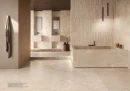 Płytka gresowa, podłogowa imitująca kamień w beżowym odcieniu, wykończenie powierzchni matowe, Emil Ceramica Unique Intensity Purestone Beige Naturale 120x120 EMLF położona na podłodze oraz ścianie w łazience gdzie znajduje się duża wanna i wiszące lustra