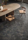 Płytka gresowa, podłogowa imitująca kamień w grafitowym kolorze, wykończenie powierzchni matowe, Emil/Provenza Unique Intensity Cobblestone Black Naturale 60x120 EML4  położona na podłodze w pomieszczeniu gdzie znajduje się drewniany stół oraz krzesła