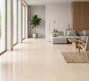 Płytka gresowa, podłogowa imitująca kamień w beżowym odcieniu, wykończenie powierzchni matowe, Tunisia Beige Matt Carving 120x120, położona na podłodze w salonie gdzie znajduje się szary wypoczynek, dywan oraz duże okna