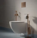 Aranżacja łazienki w minimalistycznym stylu z białą wiszącą misą wc, stojakiem na papier oraz baterią bidetową podtynkową Omnires Y kolor miedź szczotkowana SYSYBI2CPB