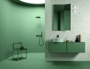 Impronta Decora Terrazzo Acrobaleno 120x120 IDE012ARC gresowa płytka imitująca lastryko ułożona na ścianie łazienki w otoczeniu zielonych miętowych płytek, zielonych mebli oraz białej umywalki nablatowej. Duże prostokątne lustro w zielonej ramie.