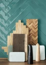 Inspirująca aranżacja kuchenna z kolekcją Marazzi Luz Ottanio Lux 5,3x30 cm MFM7 ułożoną w jodełkę. Błyszczące płytki w odcieniu morskim stanowią tło dla drewnianych desek do krojenia, kamiennych tac i stylowych młynków. Kontrast kolorów i faktur