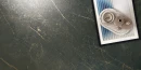 Płytka gresowa imitująca czarny strukturalny marmur ze złotą żyłą Sichenia Prestige Laurent Satin 3D 60x60 na podłodze. Jako dekorację wykorzystano tu kolorową podstawkę z wazonami oraz świeczką.