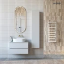 Oltens Nordlis lustro 50x120 cm owalne z oświetleniem z przodu z matą grzewczą złoty 64104800 - lustro zawieszone na ścianie w łazience gdzie znajduje się biała szafka z biała umywalką oraz grzejnik