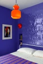 Sypialnia z dekoracyjną ścianą wykończoną połyskującymi płytkami cegiełkami Marazzi Luz Cobalto Lux 5,3x30 cm MFMS w intensywnym kobaltowym kolorze, tworzącymi nowoczesną i designerską aranżację wnętrza.