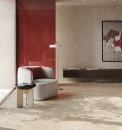 Fap Ceramiche Materia Eclecttica BeigeMatt R10 60x120- Kremowe płytki gresowe imitujące lastryko z wielokolorowym oczkiem na podłodze salonu. Czerwona ściana stanowiąca kontrastująca z ciepłym odcieniem beżu Szary fotel i ciemna szafka.