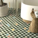 Vives Surf Multicolor 20x20- podłogowa płytka gresowa w geometrycznych kształtach i wielokolorowej powierzchni na podłodze łazienki. Wolnostojąca wanna na drewnianym podeście. Chromowana bateria wolnostojąca wannowa