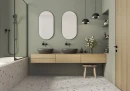 Bestile Blesle White 60x60- gresowa płytka imitująca jasne lastryko z kolorowym wyraźnym oczkiem na podłodze przytulnej łazienki. Zielone płytki na ścianie, drewniane zabudowy, czarna armatura podtynkowa oraz zaokrąglone lustra na ścianie.