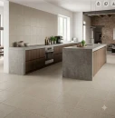 Nowoczesna aranżacja jasnej kuchni z beżowymi płytkami gresowymi Marazzi SistemT Graniti Panna Rock 20x20 cm M1W9 na podłodze oraz na ścianie nad blatem. W tle drewniane meble kuchenne, betonowe blaty, wyspa kuchenna.