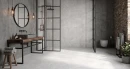 Ecoceramic Babilon Perla Matt 60x120- szara płytka imitująca beton z jasnymi przebarwieniami w stylu lofotowym na podłodze otwartej i przestronnej łazienki. Czarne akcenty idealnie współgrają z surowym betonem i czerwoną cegłą.