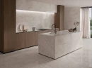 Ecoceramic Bruma White Matt 60x120- Gresowa płytka imitująca szary jasny kamień z lekkimi pęknięciami i przebarwieniami na wyspie kuchennej. Drewniana zabudowa kuchenne, duże okno balkonowe.