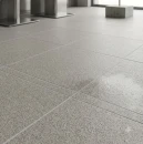 Kwadratowe, szare płytki gresowe Marazzi SistemT Graniti Grigio Chiaro Antislip o wymiarach 30x30 cm, ułożone na podłodze. Powierzchnia płytek ma matowe, antypoślizgowe wykończenie o strukturze drobnoziarnistego granitu w jasnoszarym odcieniu.