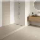 Nowoczesna łazienka z beżowymi, kwadratowymi płytkami Marazzi SistemT Graniti Panna 20x20 cm na podłodze i ścianie pod prysznicem. Obok drewniana szafka z umywalką.