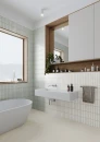 Gayafores Deco River Aqua 32x62,5- Niebieska, dekoracyjna, ryflowana, ścienna płytka dekoracyjna w połysku na ścianie łazienki. Biała wanna wolnostojąca, wnęka z lustrem i drewnianą zabudową. Biała wisząca umywalka.
