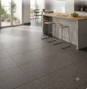 Szare płytki podłogowe Marazzi SistemT Graniti Grigio Scuro Diamond 20x20 cm M7LK w nowoczesnej kuchni z wyspą o betonowej podstawie i drewnianym blacie.