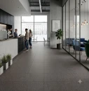 Podłoga w nowoczesnym lobby biurowym wykonana z ciemnoszarych płytek gresowych Marazzi SistemT - Graniti Grigio Scuro 20x20 cm MRU4. Matowa powierzchnia o technicznej, drobnoziarnistej strukturze jest dobrze widoczna dzięki naturalnemu oświetleniu.