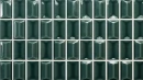 Prostokątne, ciemnozielone płytki ścienne WOW 3DB Diamond Emerald Gloss 12,5x25 cm o błyszczącym wykończeniu i trójwymiarowym, wypukłym kształcie przypominającym szlif diamentu, ułożone w regularny wzór z jasną fugą.