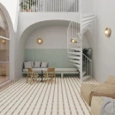 Jasny salon z antresolą i białymi kręconymi schodami. Podłoga w geometryczną kratkę z wykorzystaniem błyszczących seledynowych płytek WOW Bits Square Celadon Gloss 11,6x11,6 133022. W głębi wnęka z siedziskiem, małym stolikiem i drewnianymi krzesłami.