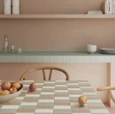 Aranżacja nowoczesnego wnętrza z wykończonym kafelkami blatem i stołem. Błyszczące, jasne płytki WOW Bits Tundra Gloss 3,7x11,6 cm ułożono w geometryczny wzór na stole razem z płytkami w pastelowych odcieniach beżu i mięty.