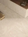 Emil Ceramica Dual Travertine Poro Aperto Beige Silktech Rett. 60x120 ENPX gresowa płytka imitująca beżowy klasyczny trawertyn z jasnymi przebarwieniami na podłodze salonu. Drewniana ława, kamienna wyspa z drewnianym blatem.