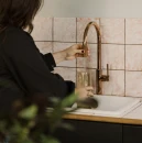 Kuchnia ze ściennymi kafelkami, białym zlewozmywakiem oraz baterią kuchenną stojącą z zestawem do filtrowania wody Omnires SWITCH, miedź połysk SW9057-FD1CP