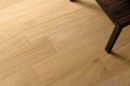 Coem Afromosia Miele Esterno Rettificato 15,1x90,6 AF192ER gresowa płytka imitująca drewno w naturalnym kolorze na posadzce salonu. Ciemne drewniane meble.