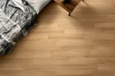 Coem Afromosia Miele Esterno Rettificato 15,1x90,6 AF192ER gresowa płytka imitująca drewno w naturalnym kolorze na posadzce salonu. Ciemne drewniane meble.