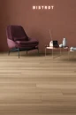 Coem Afromosia Ecru Naturale Rettificato 15,1x90,6 AF193ER gresowa płytka imitująca jasne brązowe naturalne drewno na podłodze kawiarni. Bordowy fotel, metalowy miedziany okrągły stolik.