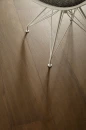 Coem Afromosia Moro Esterno Rettificato 15,1x90,6 AF190ER gresowa płytka imitująca ciemne brązowe drewno na podłodze salonu. Metalowe krzesło w białym kolorze i szarym obiciem